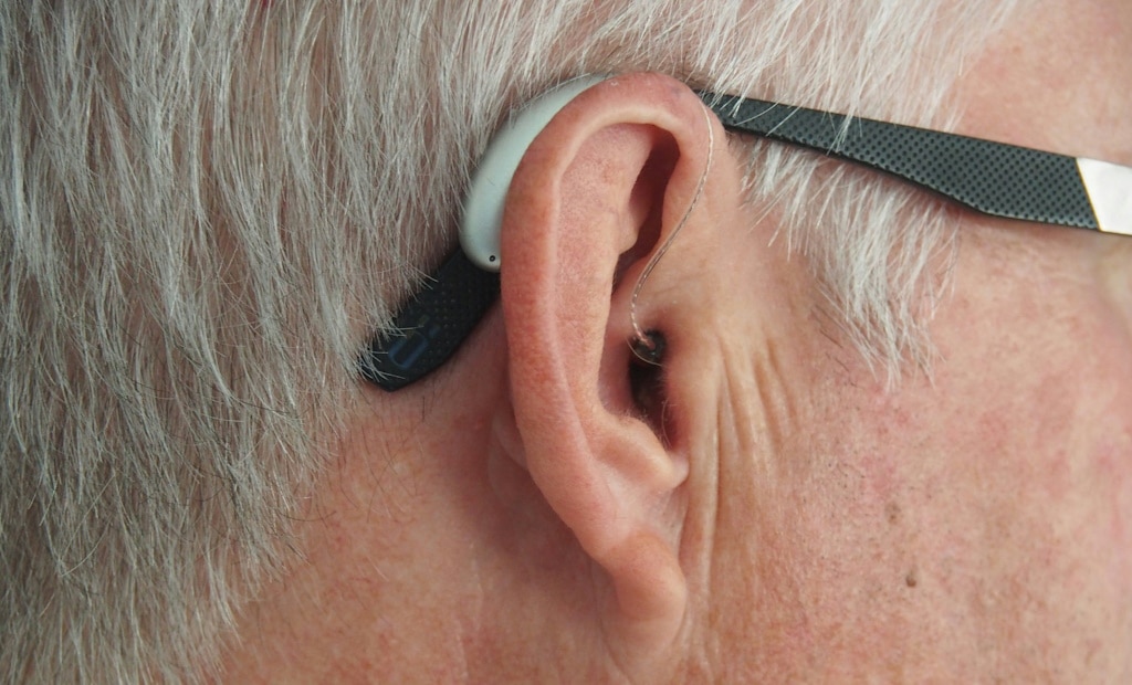 Close-up of a behind-the-ear hearing aid attached to a man's ear