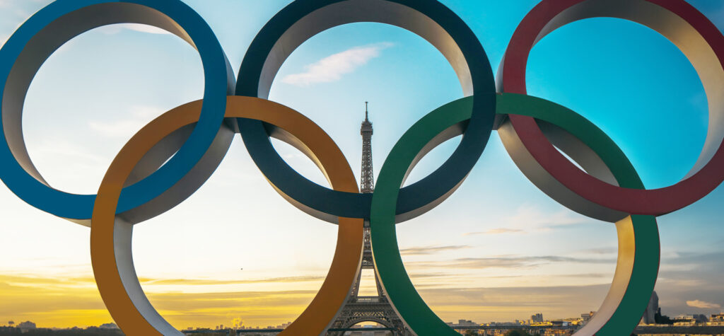 Close-up of Olympic rings with the Eiffel tower visible behind