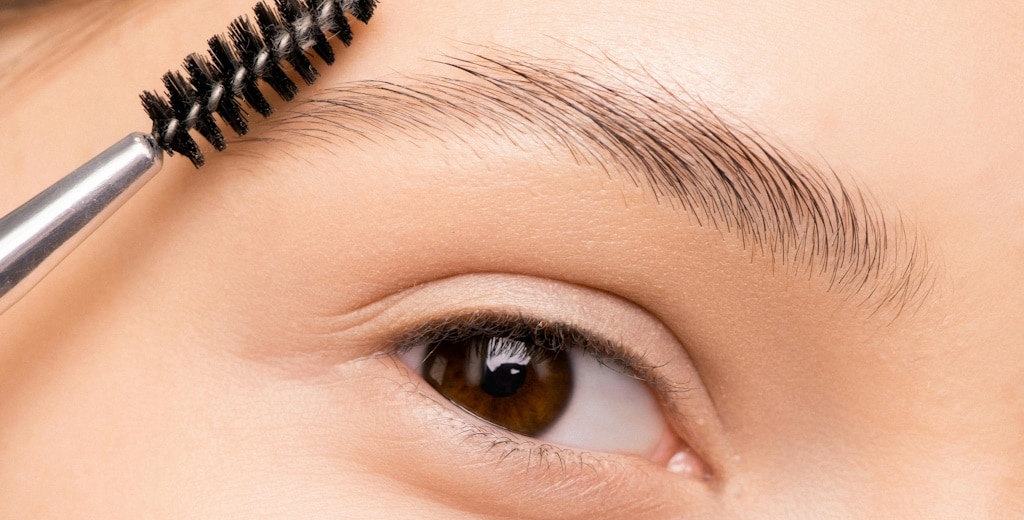 Close-up of a woman working on her eyebrow