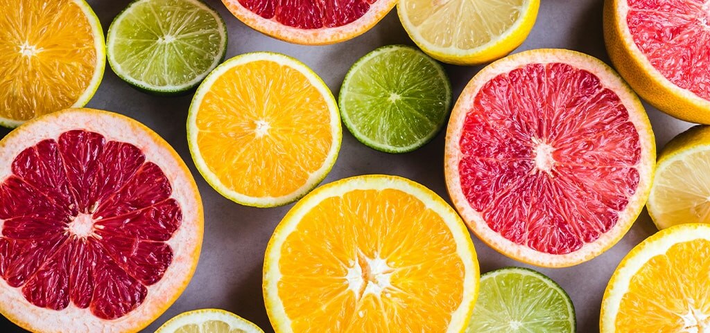 A close-up of sliced citrus fruits, including grapefruits, lemons and limes. 