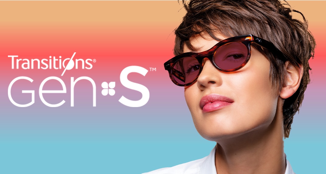 Transitions® GEN S™ main image. A close-up of a young lady with short brown hair. She is wearing tortoiseshell Ray-Ban sunglasses with ruby lenses. She is on a multi-coloured background which blends yellow, pink, purple and blue colours.