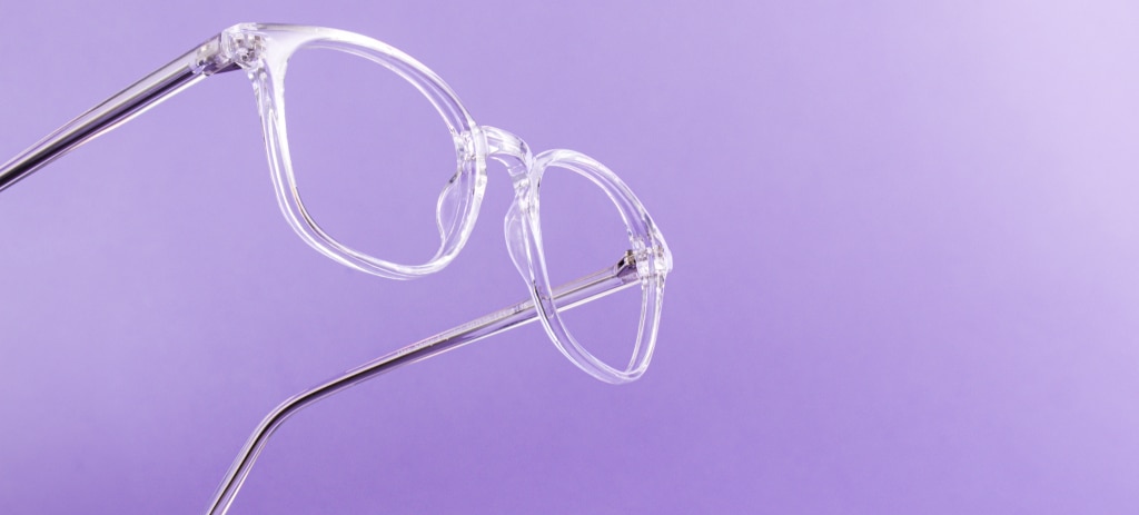 On one side of the image is a clear pair of glasses suspended mid-air on a light purple background.