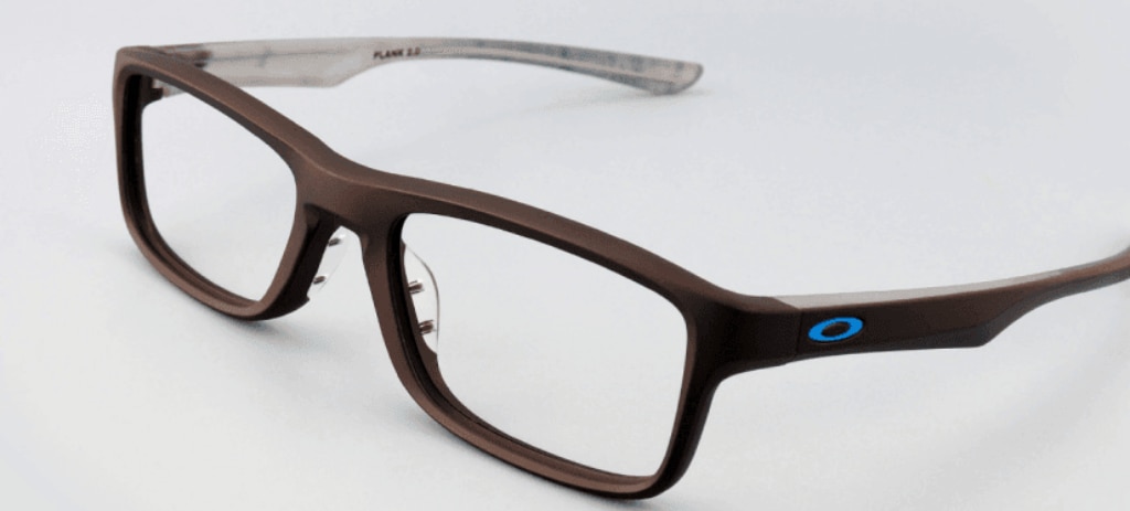 A close-up from the side of rectangular Oakley glasses in satin black, crafted from nylon and accented with a blue 'O' logo on the temples.