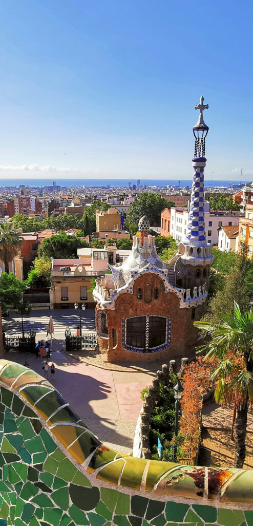 A photo of Barcelona's Park Güell with colourful Gaudí architecture, including intricate mosaics and colourful tile work.