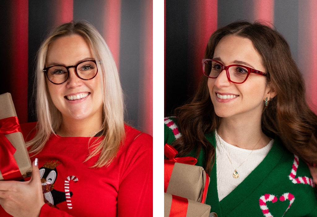 Two-image collage. First image: A woman with medium-length straight blonde hair wears red acetate round glasses and a red Christmas jumper featuring a penguin. She holds a brown gift box wrapped with a neatly tied red ribbon, standing in front of a red curtain backdrop. Second image: A woman with long wavy brown hair wears red acetate rectangular glasses, a green candy-cane cardigan over a white T-shirt, and a gold necklace. She holds brown gift boxes wrapped with red ribbons, also standing in front of a red curtain backdrop.
