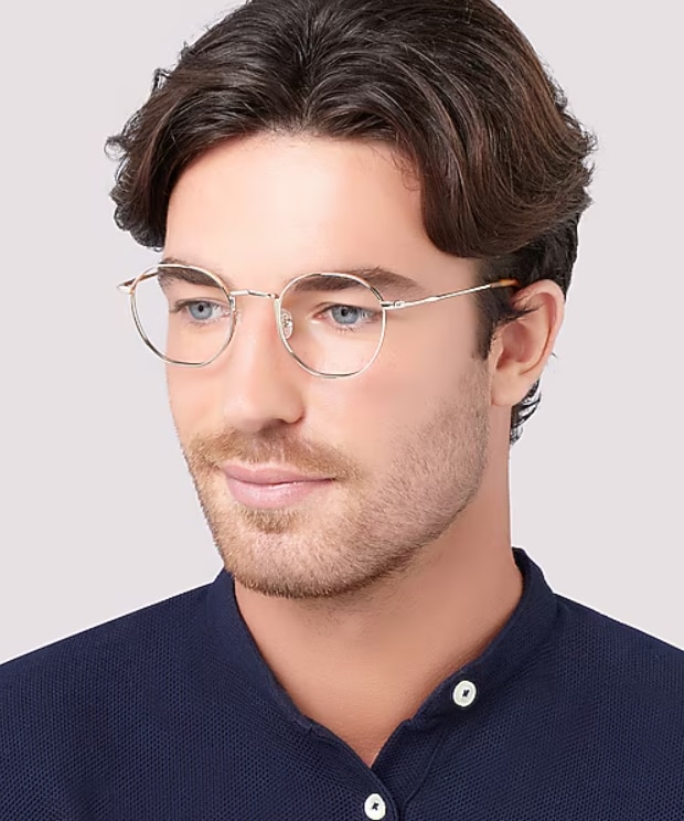 Man with brown hair wearing London Retro Radley round slim gold metal glasses against a neutral background.