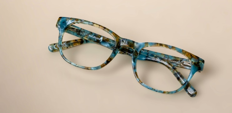 Rectangular GD Collection Andi Seaglass Sands acetate glasses laid flat against a warm neutral background.