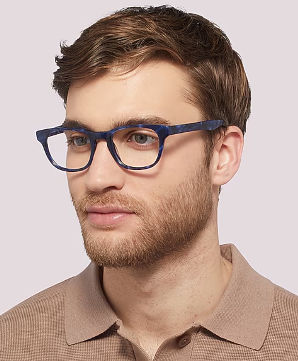 Man with light brown hair in a quiff wearing The Collection Andi rectangular blue acetate glasses against a neutral background.