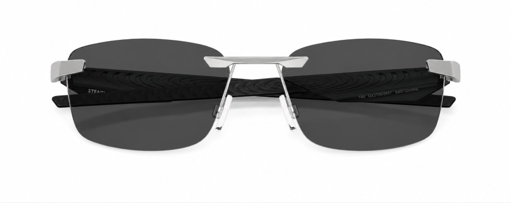 Oakley® Steakhouse 1.0 90s-inspired rimless rectangular metal glasses with thick sculpted black plastic temples, folded up against a plain white background, inspired by 90s-chic fashion.