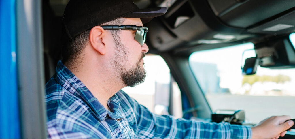 Man driving in wraparound sports sunglasses for glare protection.