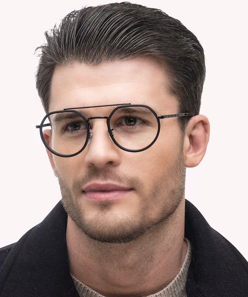 A young man with dark hair slicked back. He is looking to one side, wearing a modern geometric metal frame with a top bar and acetate detailing around the lenses.