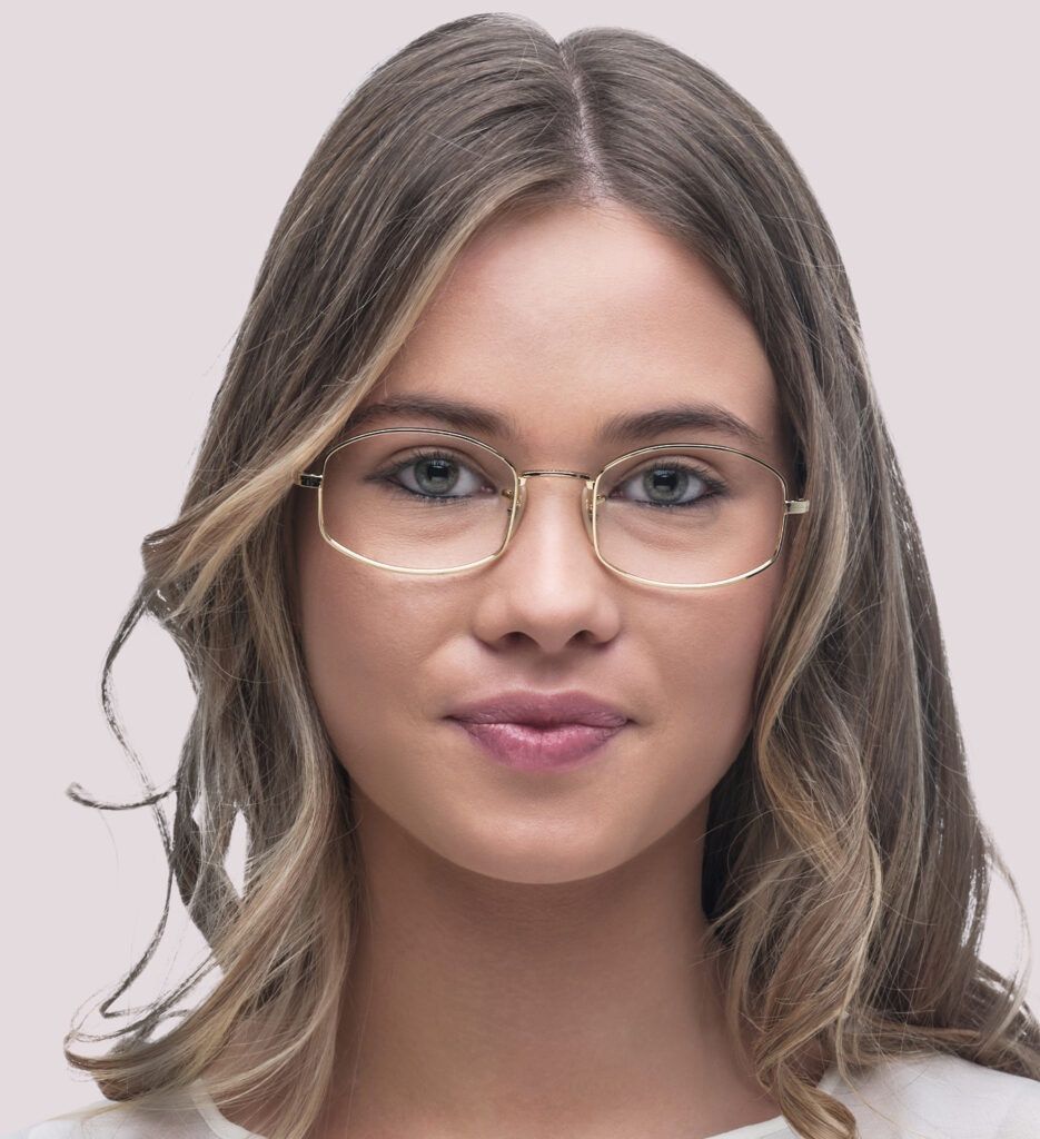 A young lady with dark blonde, medium-length hair wearing a pillow-shaped gold metal frame.