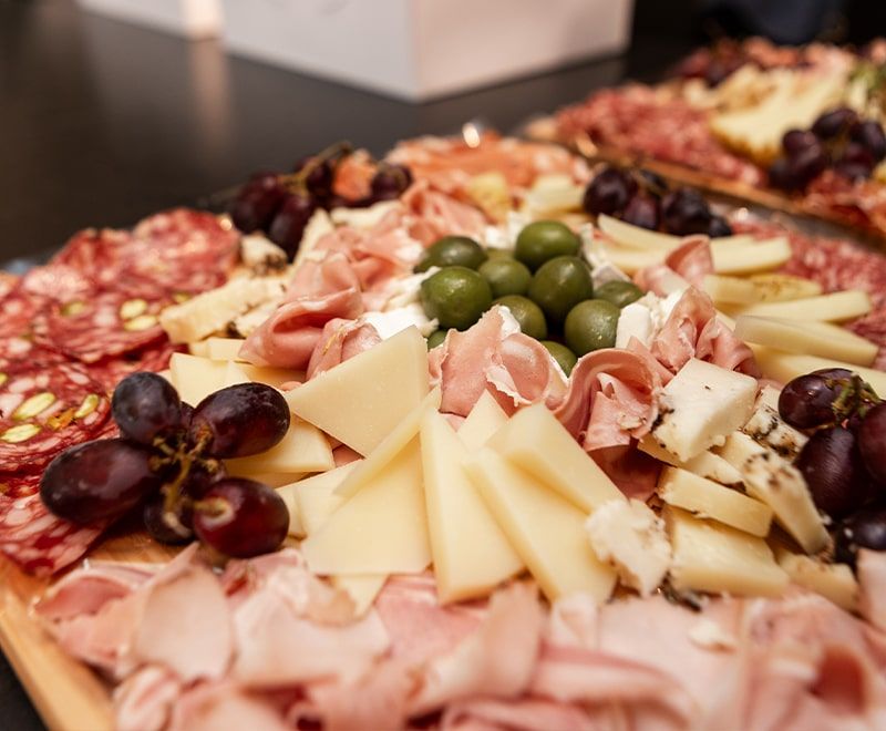 Close-up of platters of meats, cheese and grapes
