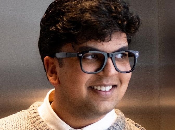Young man with dark curly hair wearing Scout Costello glasses