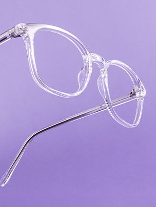 A transparent pair of glasses on a purple background