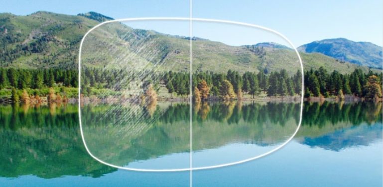 Illustration showing a lens with anti-scratch protection over a landscape scene. The left side of the lens appears covered in scratches and surface marks, while the right side remains clear and sharp, demonstrating how scratch-resistant coatings help main