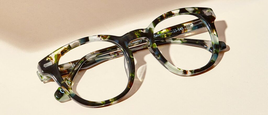 Flaylay of green tortoiseshell, acetate Hart frame on a beige background