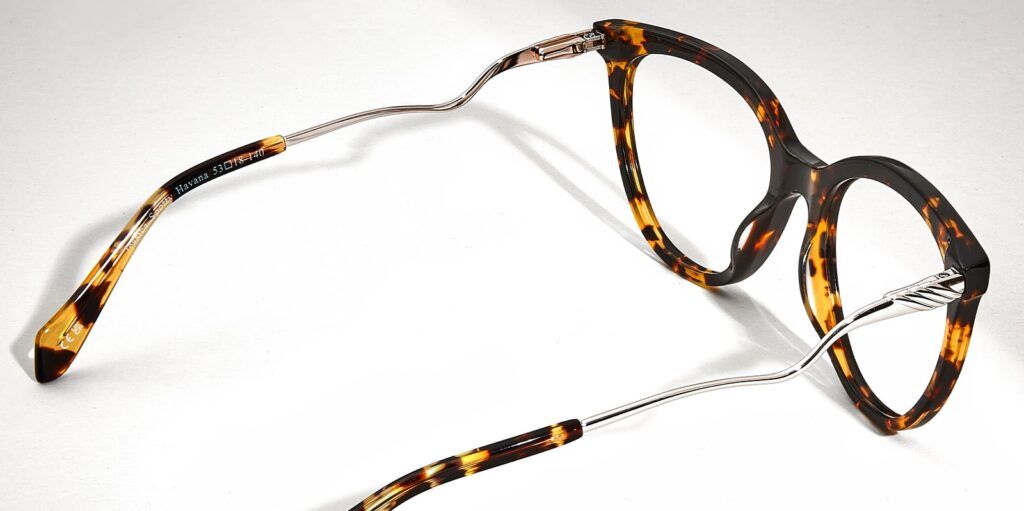 Dark brown, tortoiseshell, acetate Scout frame with grey metal wavy arms facing right corner on light grey background