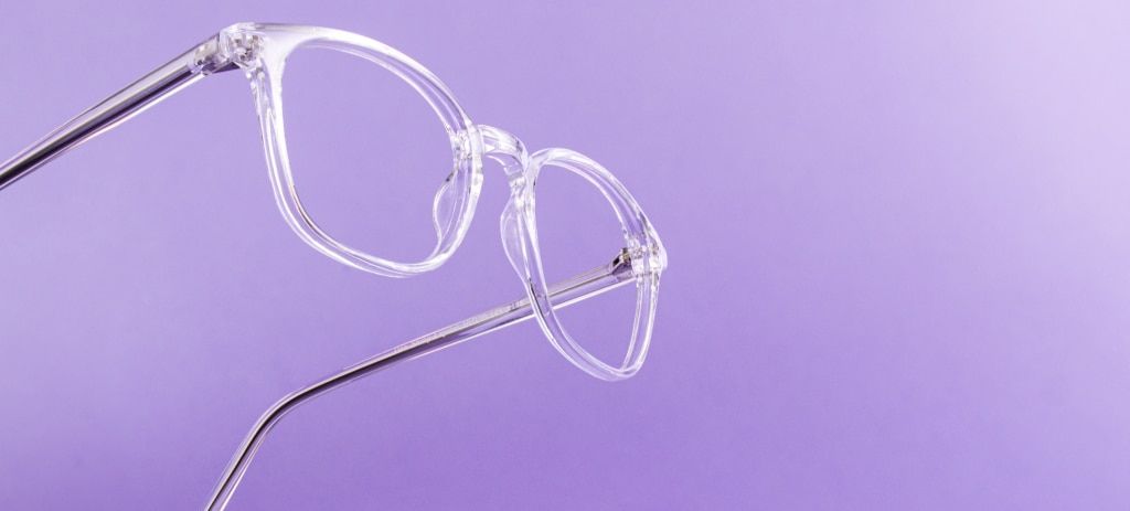 On one side of the image is a clear pair of glasses suspended mid-air on a light purple background.