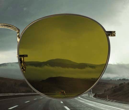 An olive-green tinted lens with a motorway scene visible behind it.