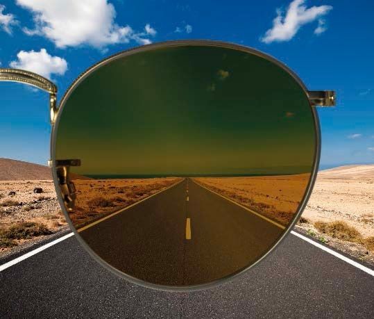 A copper-toned lens framing a long, straight road cutting through the desert landscape.