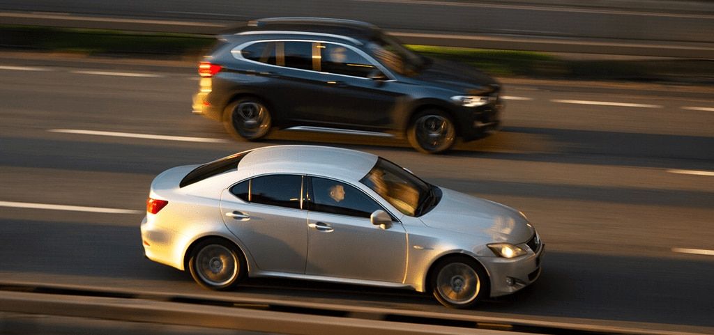 Close-up of two cars in motion driving on a motorway.