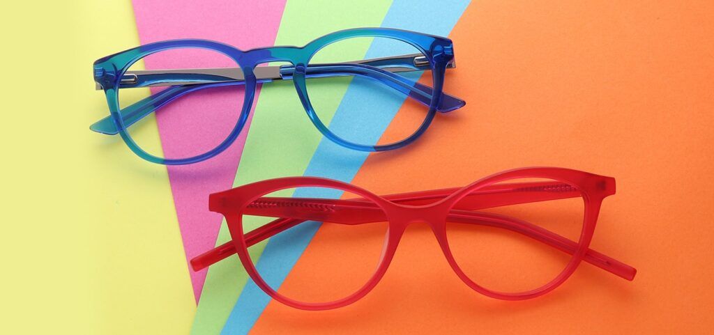 Flatlays of two pairs of virant acetate frames, one blue and one red placed on multicoloured paper of orange, blue, green, pink and yellow in a fan style