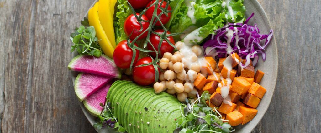 Healthy bowl of veg with avocados, butternut, vine tomatoes, cabbage, lettuce peppers and crest