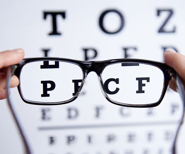 A blurry eye chart appearing more focused through a pair of glasses