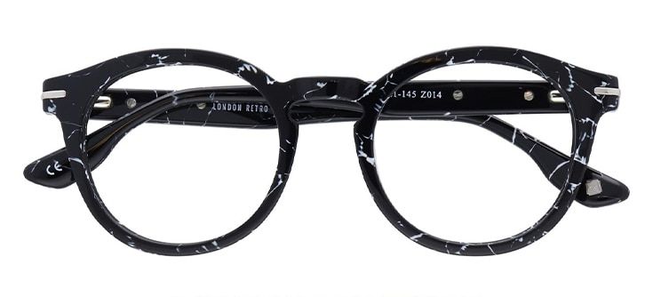 A chunky round frame made of black acetate with subtle marble detailing