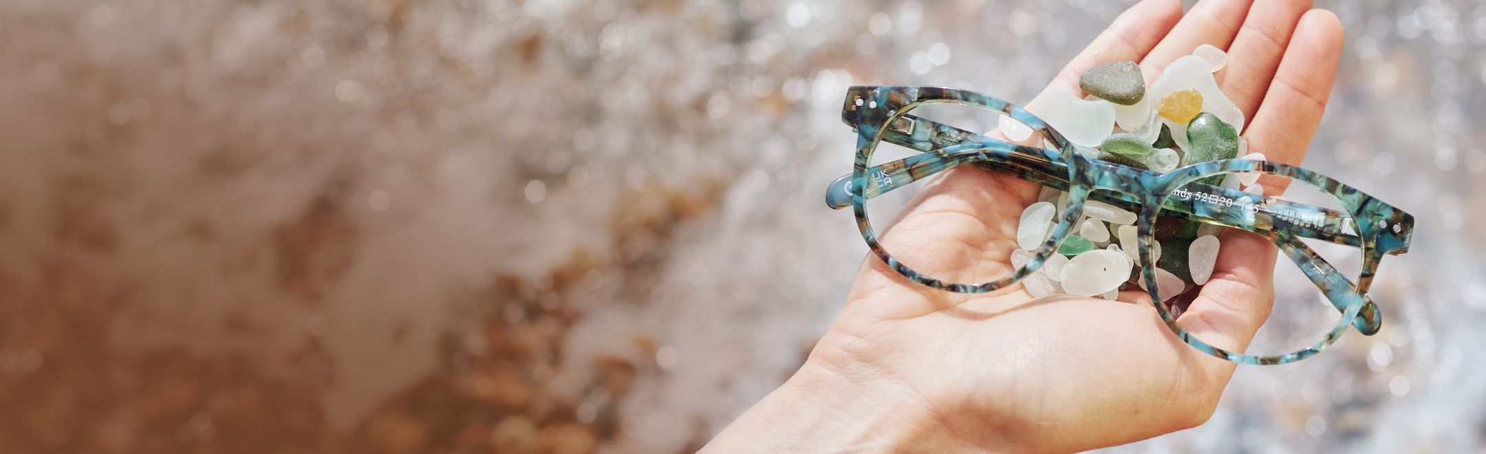 Close-up of details of Seaglass Sands frames held on palm