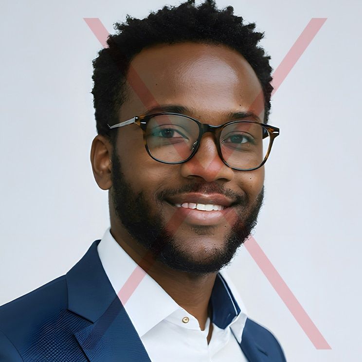 A cropped headshot of a young man with dark hair wearing a pair of round glasses, a white shirt and blue blazer. There is a red cross through the image to indicate that it's not an appropriate passport photo.