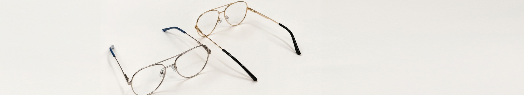 Two pairs of metal pilot frames on a light grey table
