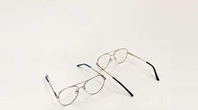 Two pairs of metal pilot frames on a light grey table