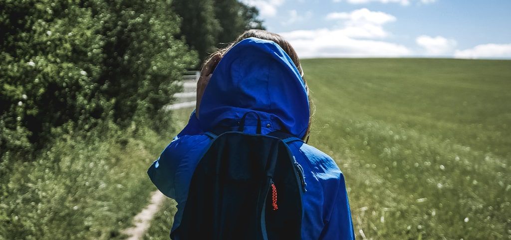 Person doing a walk wearing a back-pack and coat
