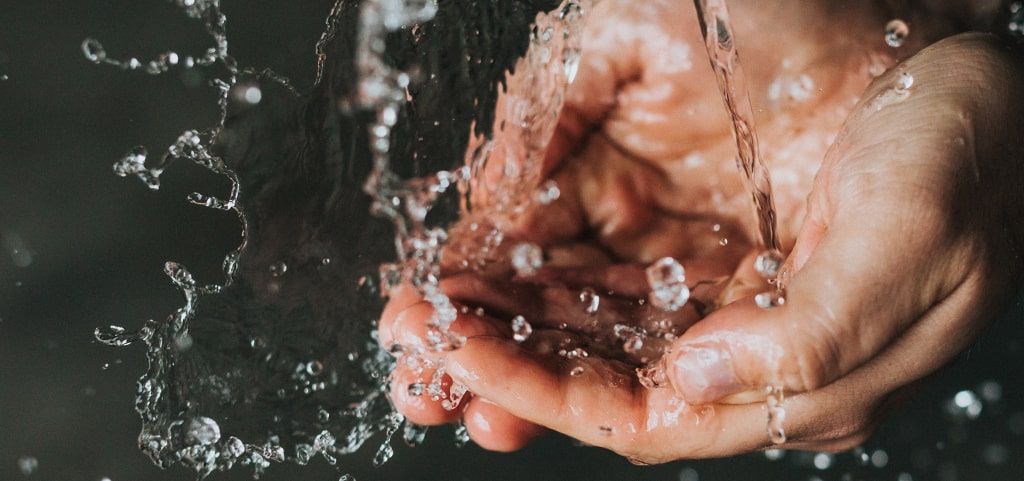 Hands clasped together gathering water