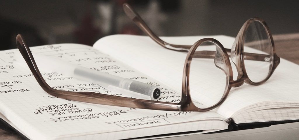 Pair of grey glasses on note pad