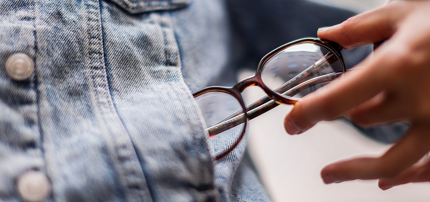 Close-up shot of a woman pulling a pair of square tortoiseshell Levi's frames