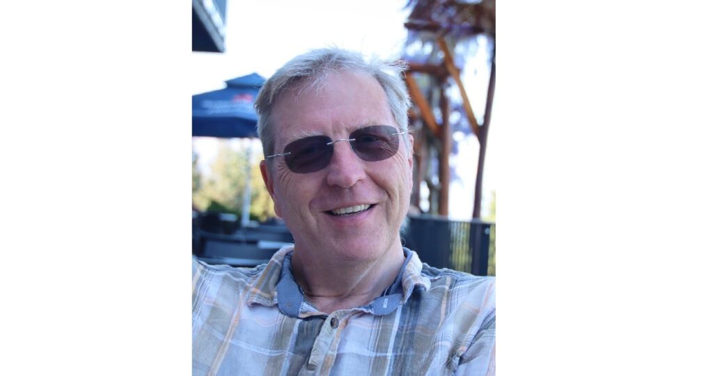 Man smiling wearing a pair of tinted rimless Finelight frames