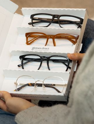 An open Home Trial box revealing four stylish frames inside