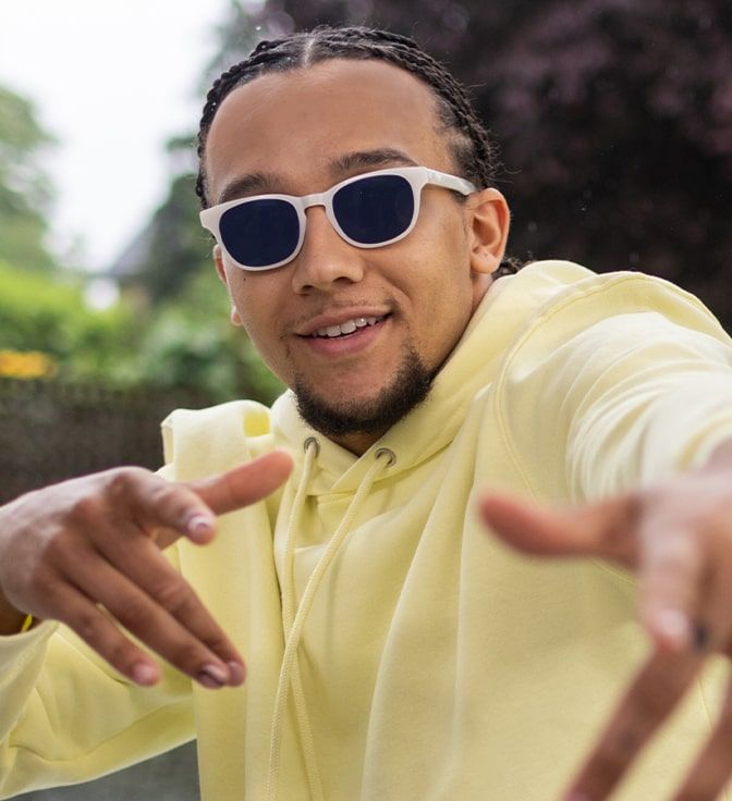 Young male wearing a pair of rectangular, white GD Collection frames with Sapphire Transitions tints
