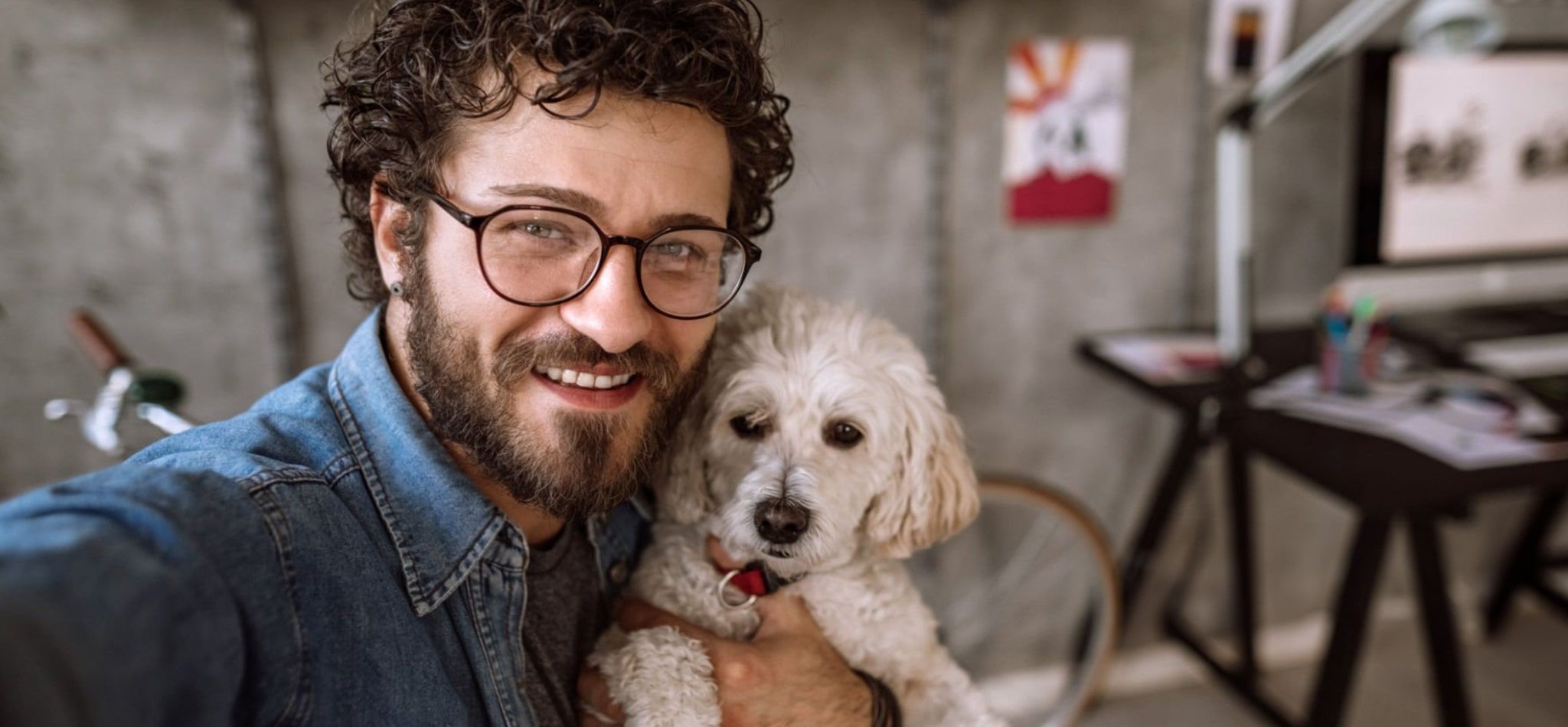 Man taking a selfie with his dog in his office