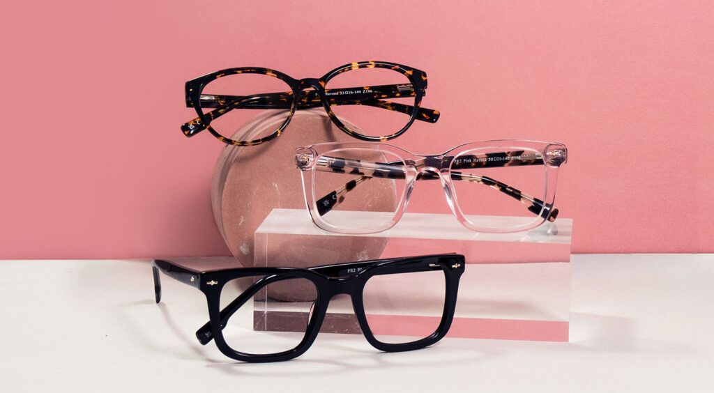 3 pairs of Pink Ribbon frames on different levels, one on the ground, one on a clear block and one on a round disc