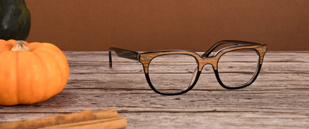 Wooden clubmaster style square London Retro frame on a wooden surface with pumpkins in the background