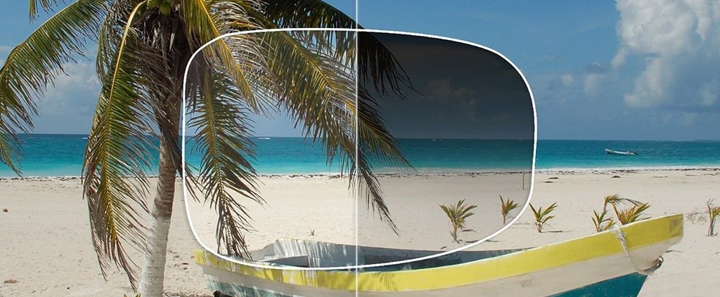 A graphic comparing a gradient-tinted lens and a clear lens, featuring a tropical scene with a palm tree, white sand, and blue ocean waters.