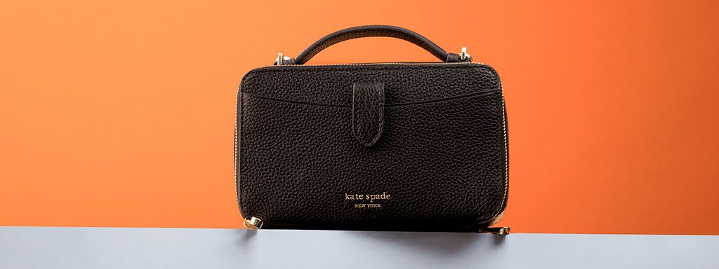 Black kate spade Hudson Double Zip Crossbody bag on a orange background