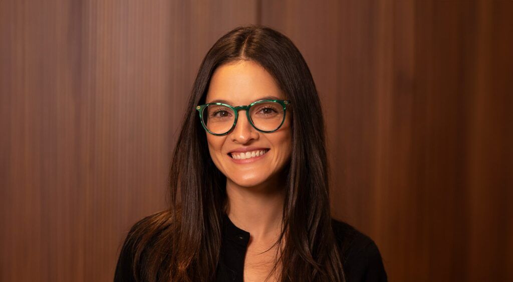 Female wearing round green frames