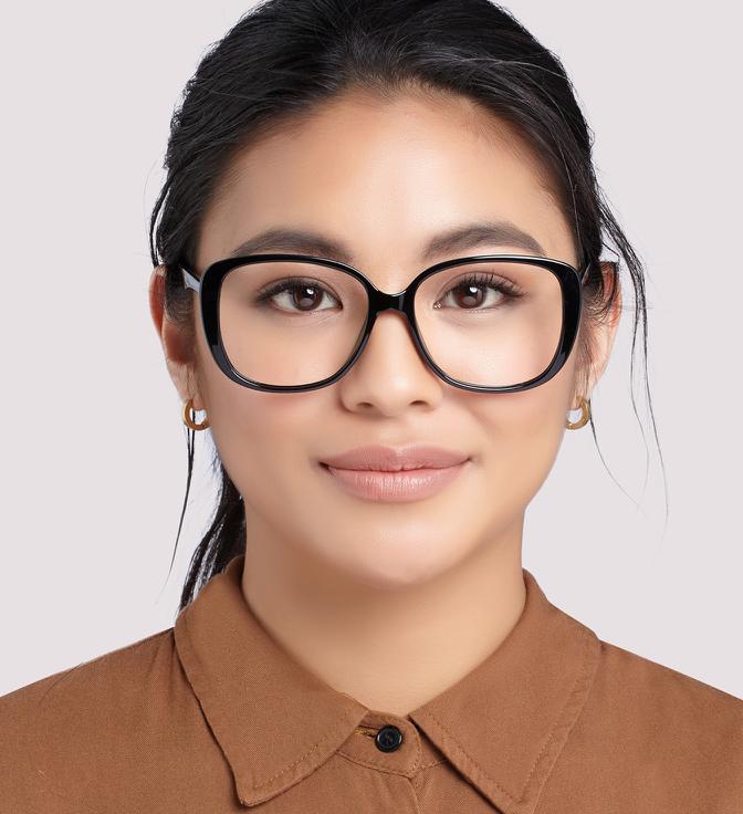 Image shows a woman wearing curved, oversized black frames with a light pink background.