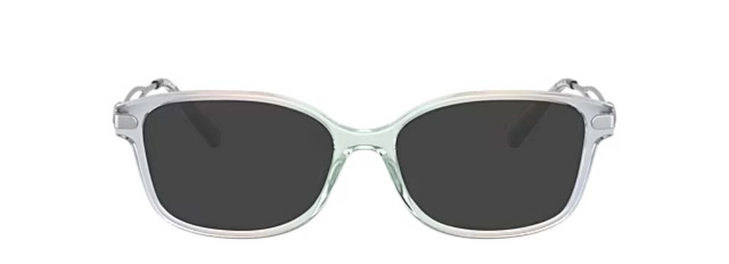 Rectangular acetate sunglasses in gradient, transparent blue. They have silver metal arms, embellished with the 'C' emblem for Coach.