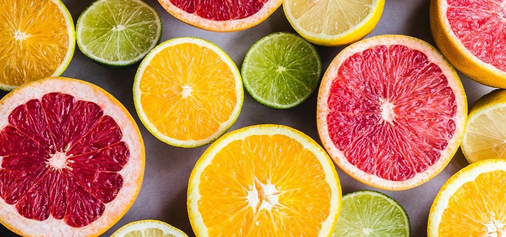 A close-up of sliced citrus fruits, including grapefruits, lemons and limes.